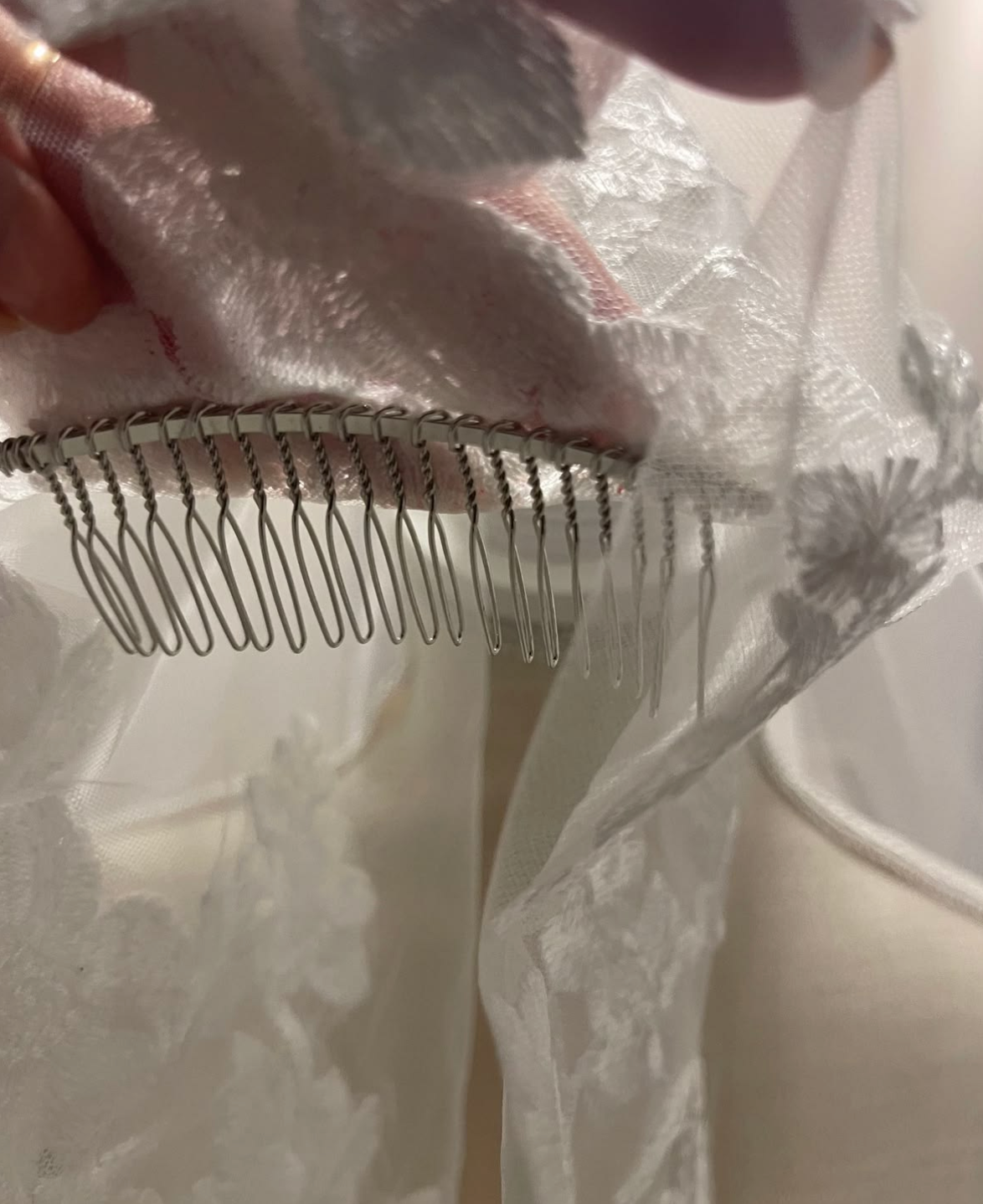 Close-up of the comb sewn into a lace-trimmed tulle veil