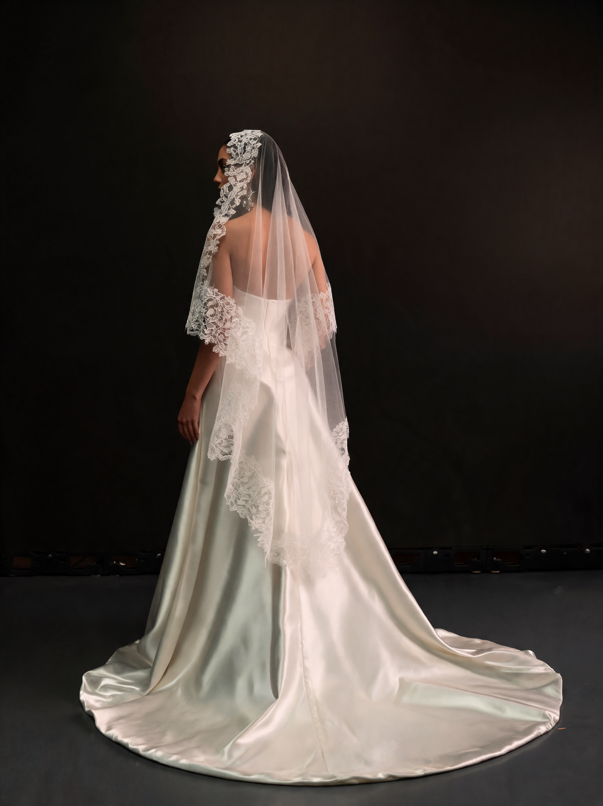 Waltz length lace-edged veil worn with a satin gown, side view