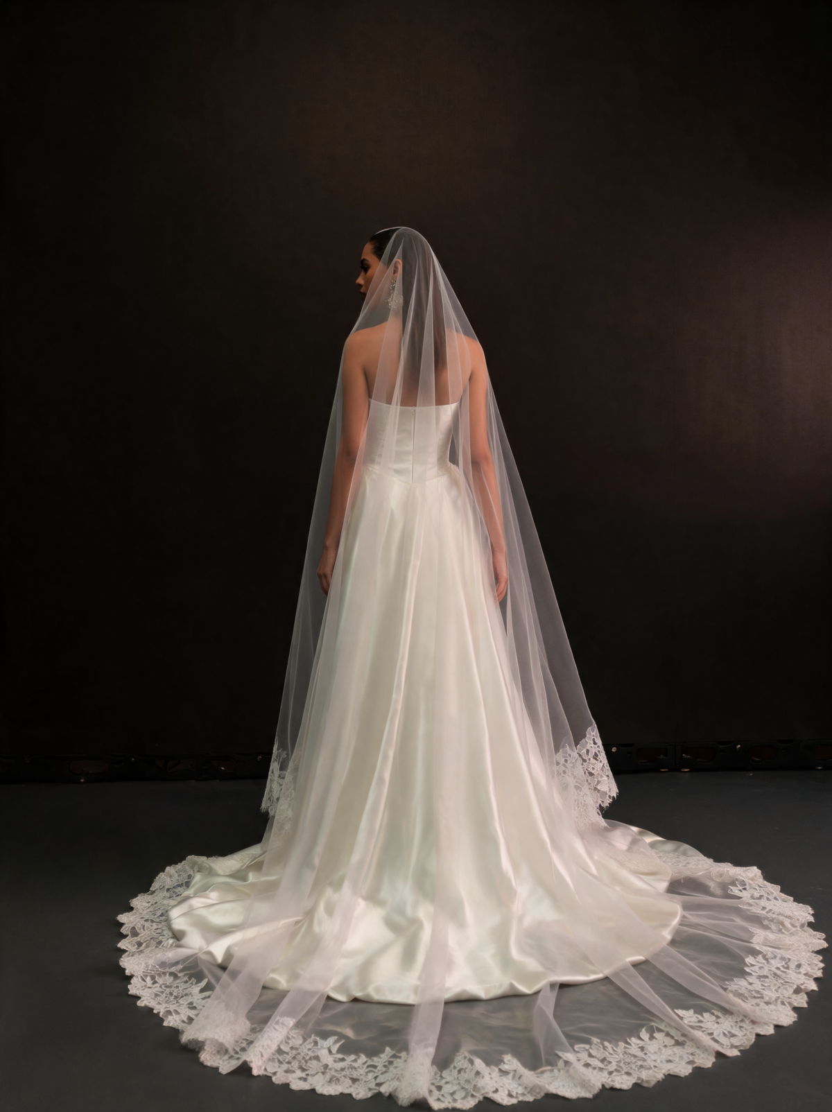 Chapel length lace-edged veil spreading on the floor, back view