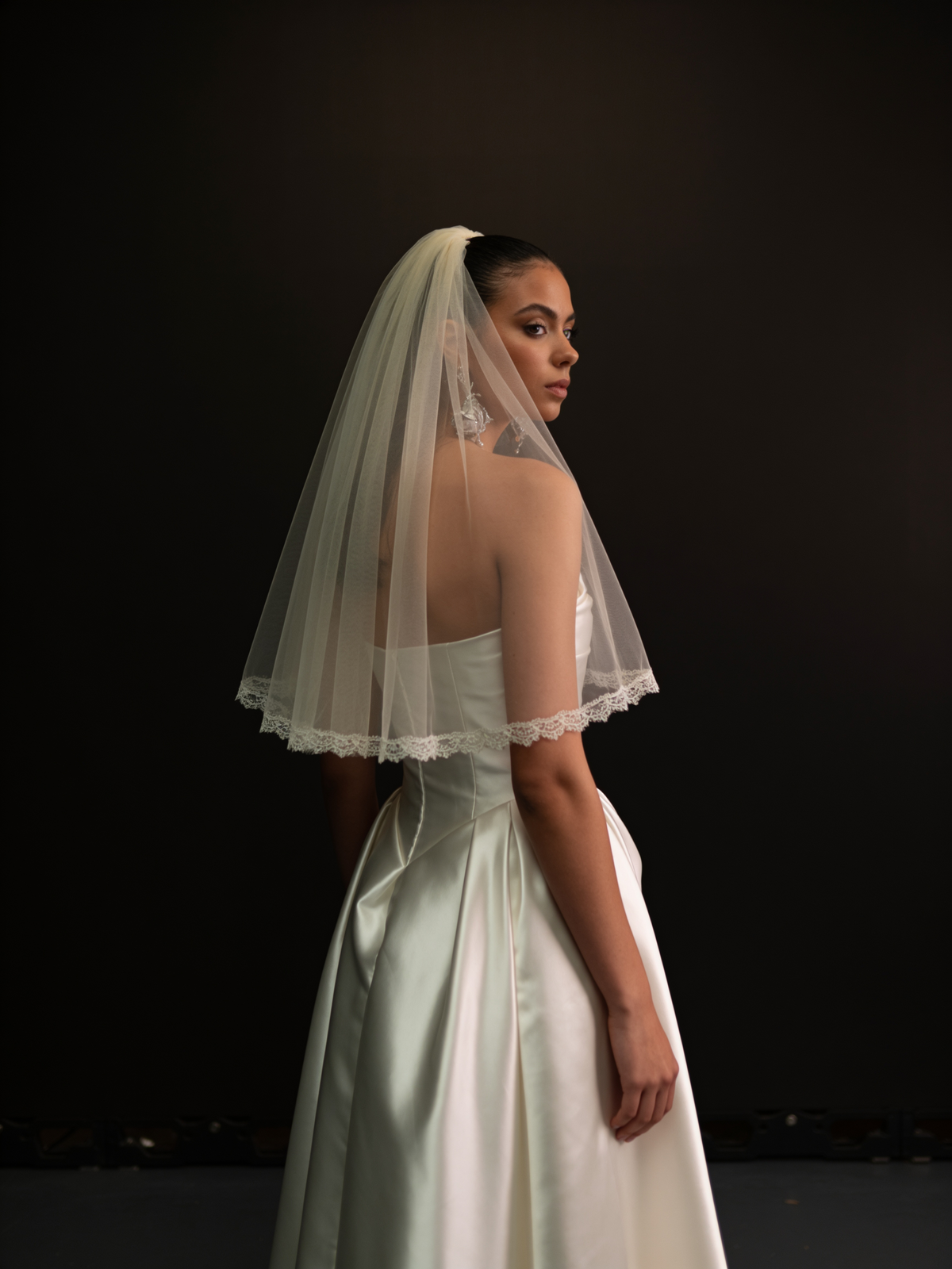 Shoulder length veil with a lace edge, back view