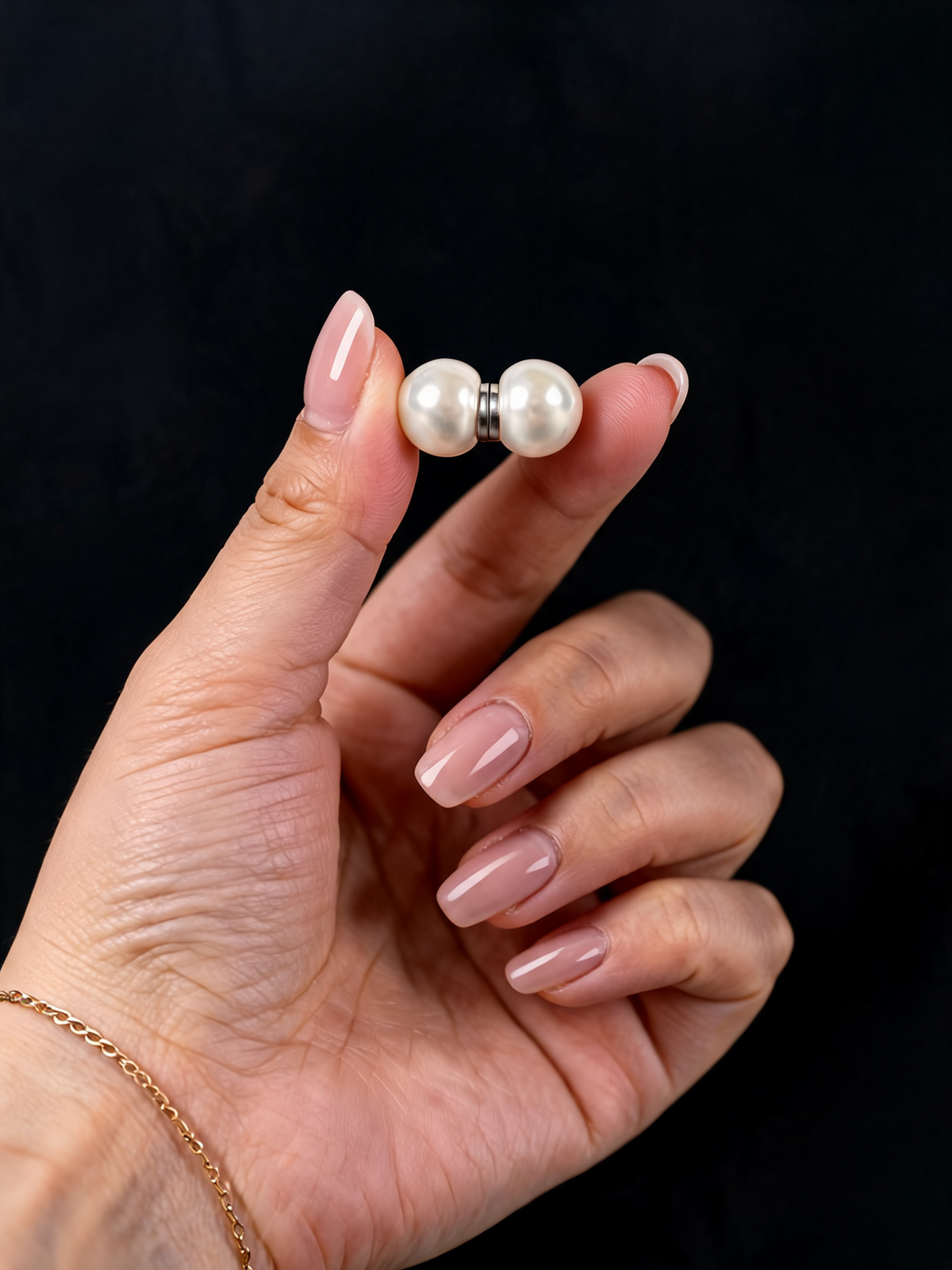 The Pearl Veil Weights — one magnetic pearl weight held between the fingers